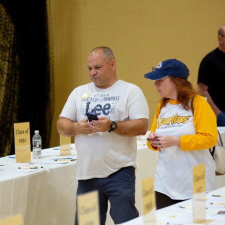 people standing next to tables with signs