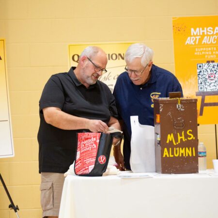 a couple of men standing next to a table