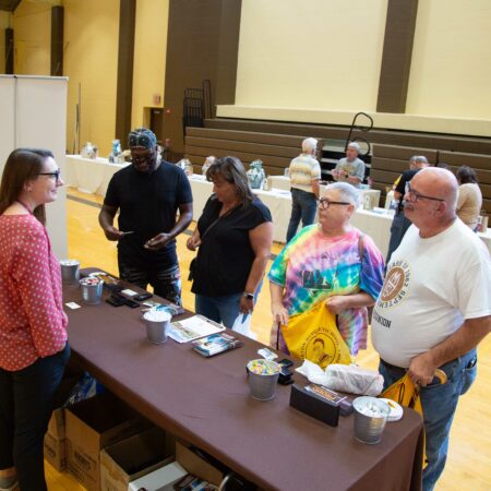 a group of people standing around a table