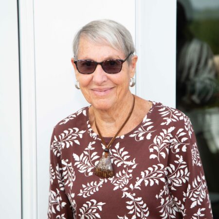a person wearing sunglasses and a necklace