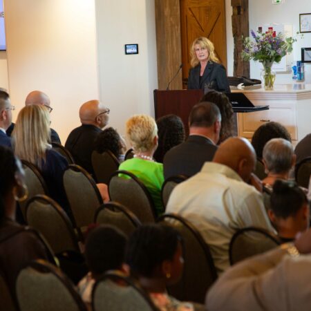 a person standing at a podium in front of a group of people
