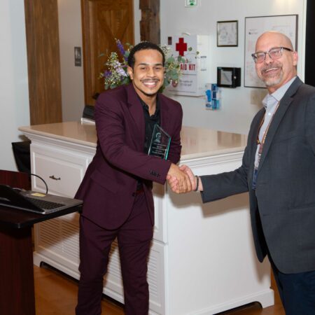 a person in a suit shaking hands with another person in a room