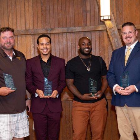 a group of men holding awards