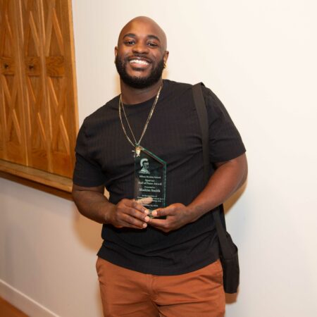 a person holding a glass award