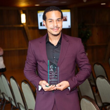a person in a suit holding a award