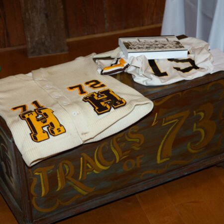 a wooden box with white t-shirts and yellow letters