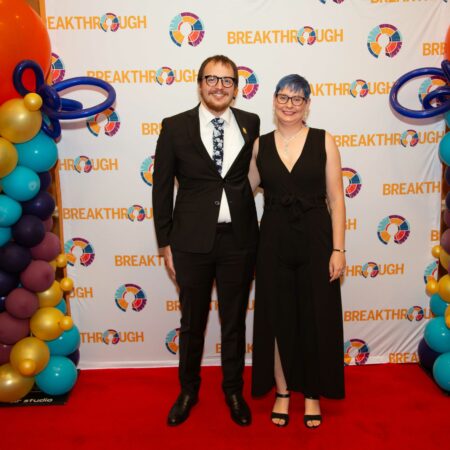 people standing in front of a wall with balloons