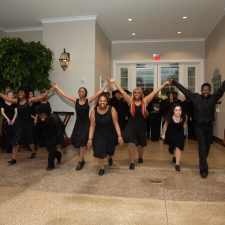 a group of people in black dresses dancing