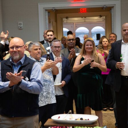 a group of people clapping in a room