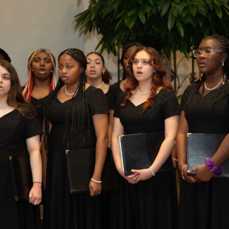 a group of women in black dresses