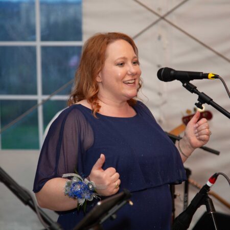 a person giving a thumbs up in front of a microphone