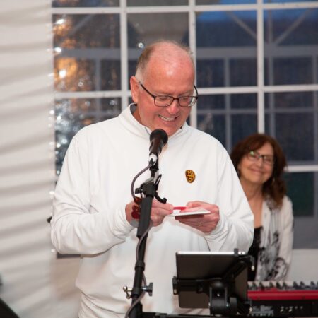 a person in white shirt standing in front of a microphone