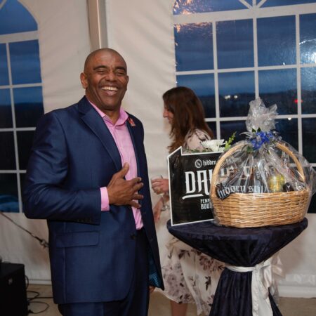a person in a suit standing next to a basket of food