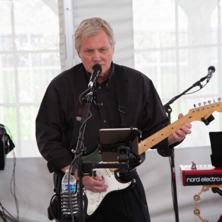 a person playing guitar in front of a microphone