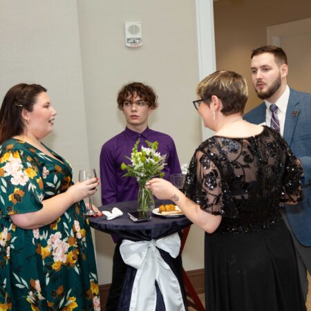 a group of people standing around a table