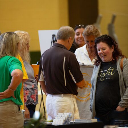 a group of people standing around a table