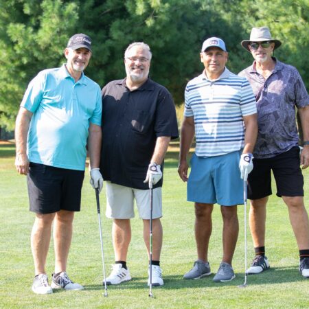 a group of people standing on a golf course