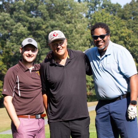a group of men standing on a golf course