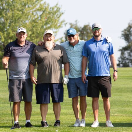 a group of men standing on a golf course