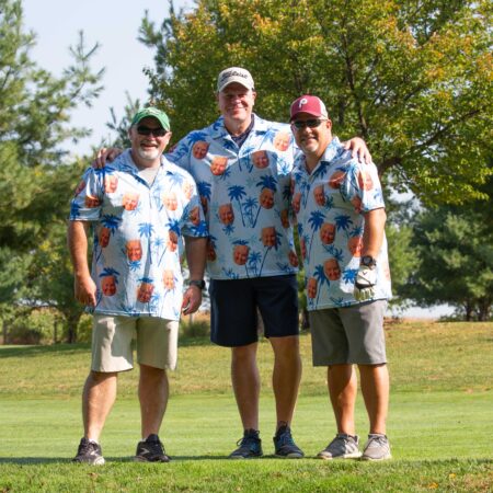 a group of men standing on a golf course