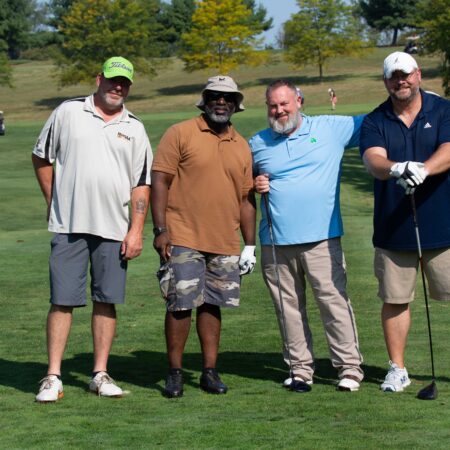 a group of men standing on a golf course