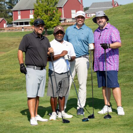 a group of men standing on a golf course