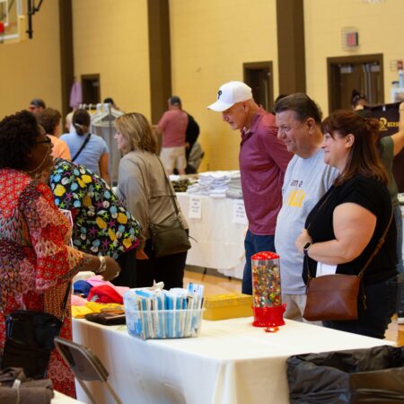 a group of people standing around a table