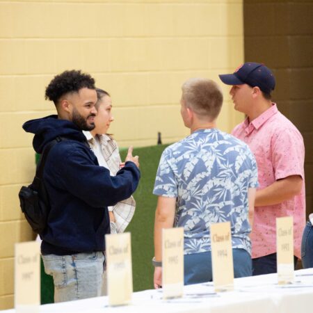 a group of people standing around a table