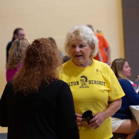a person in a yellow shirt talking to another person