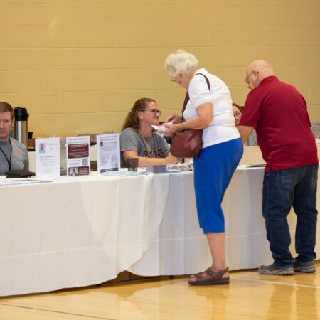 a person standing at a table with a person in front of her