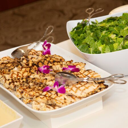 a plate of food with spoons and a bowl of salad