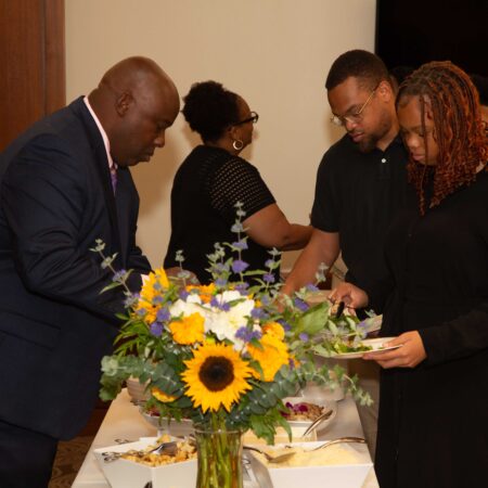 a group of people standing around a table with flowers