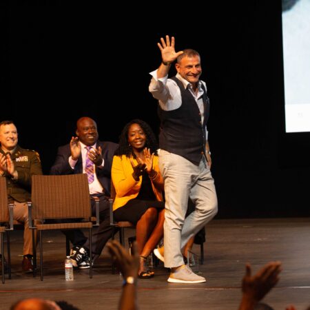 a person on stage with a crowd of people watching
