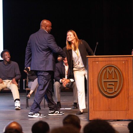 people shaking hands at a podium