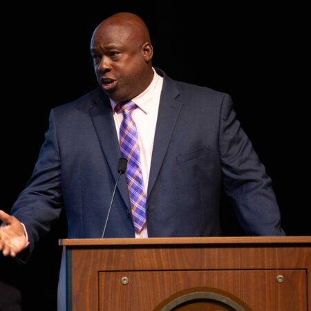 a person in a suit and tie standing at a podium