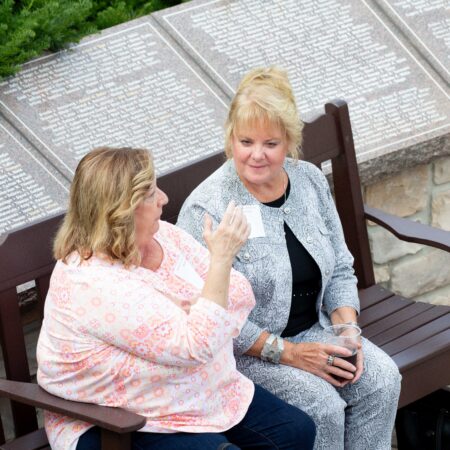 two women sitting on a bench