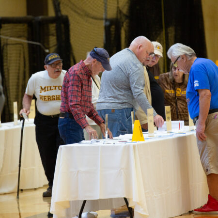 a group of people standing around a table