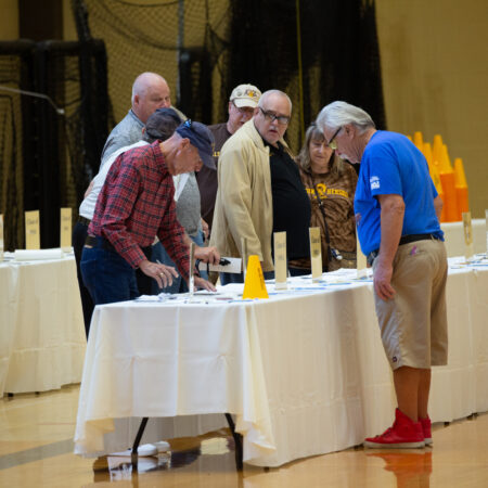 a group of people standing around a table