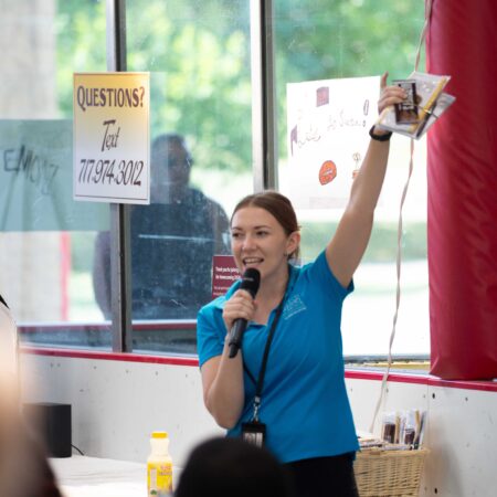 a person holding a microphone and raising her hand