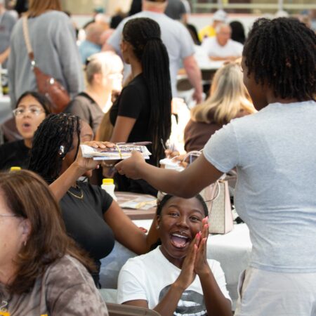 a person receiving a tray of food from a waitress