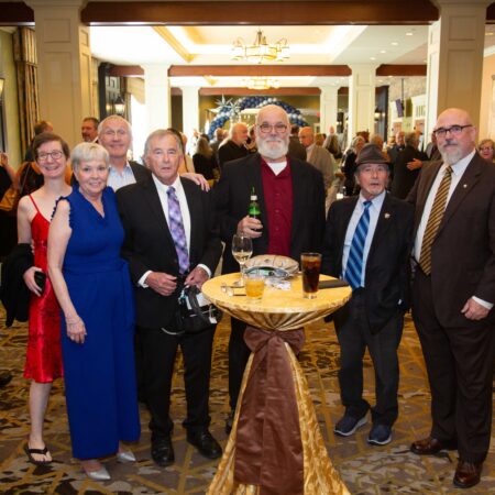 a group of people standing around a table