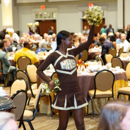 a cheerleader in a room with tables and chairs