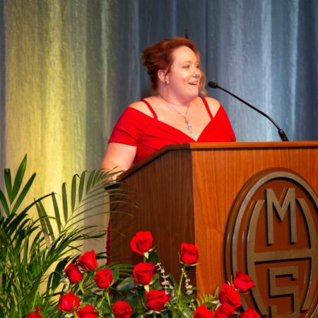 a person in a red dress at a podium