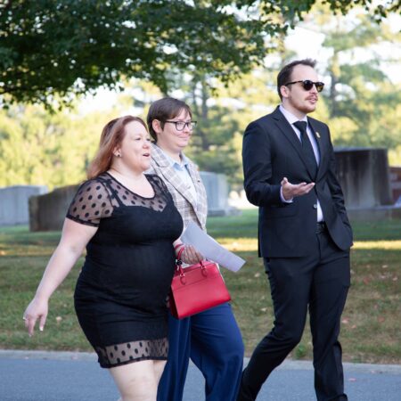 a group of people walking on a sidewalk