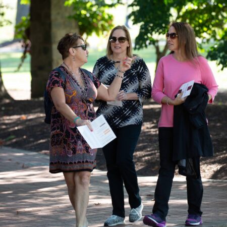 a group of women walking on a sidewalk