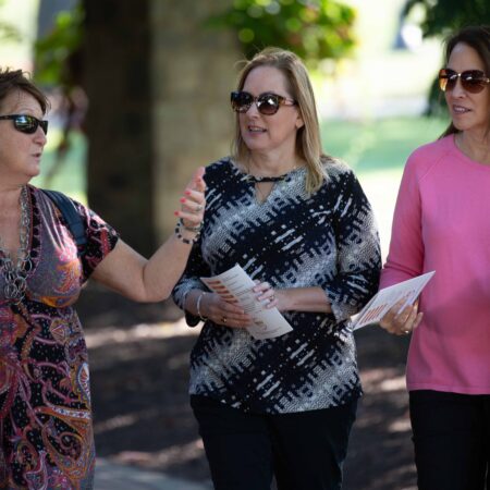 a group of women walking on a sidewalk