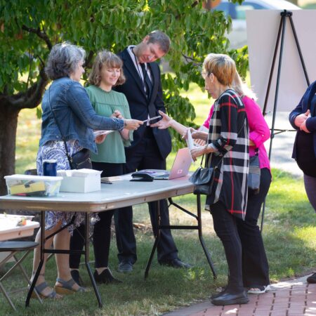 a group of people standing around a table