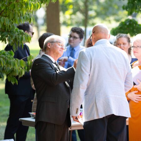 a person in a suit shaking hands with another person in a white suit