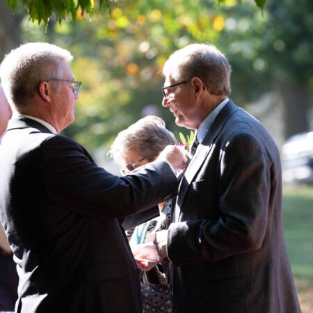 a person in suit standing next to a person