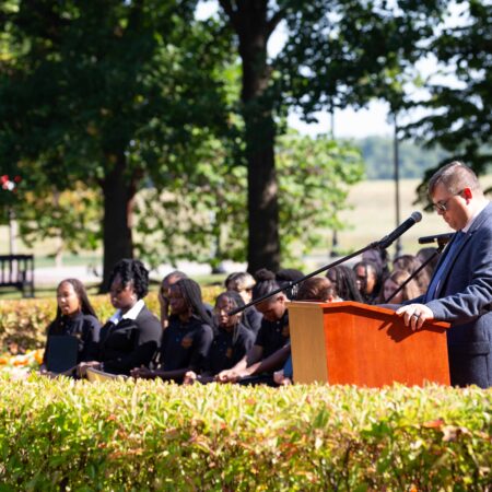 a person standing at a podium with a microphone
